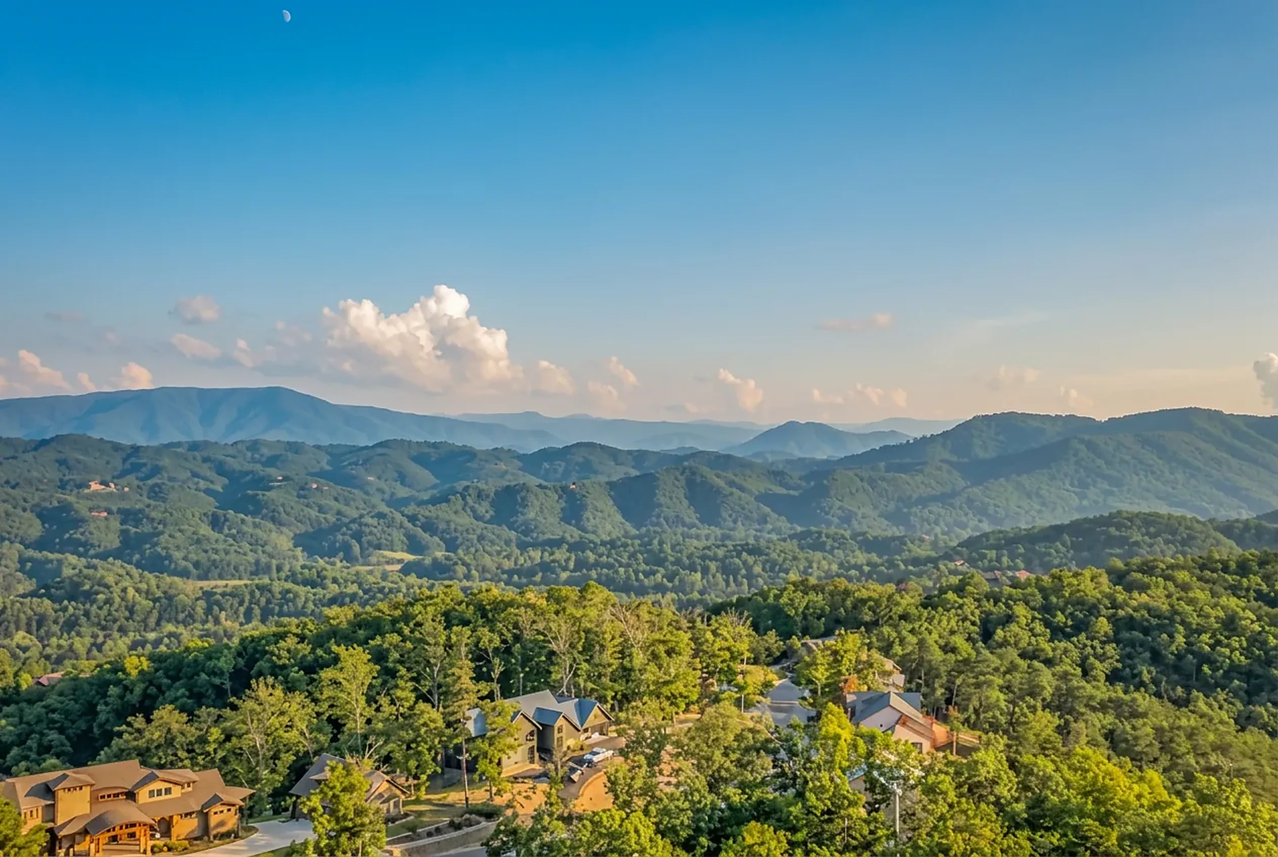 Layered blue ridges of the Great Smoky Mountains above cabins tucked into the treeline
