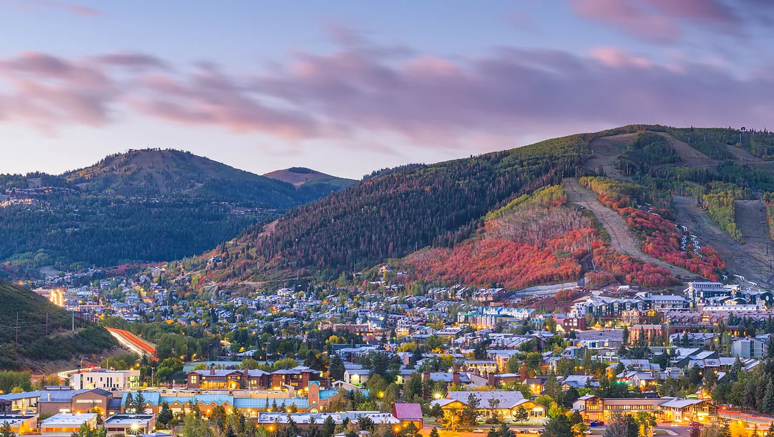 Utah mountain town in autumn color with ski runs cut into the hillside above it
